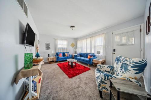 a living room with blue couches and a red rug at Cozy two bedroom one bath in Cleveland