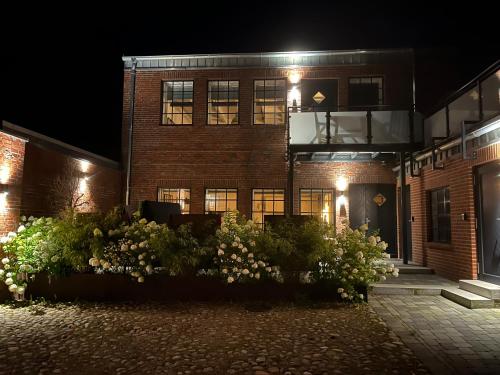 a building with flowers in front of it at night at Loftwohnung 1 Simmerdeis an der Gracht in Friedrichstadt