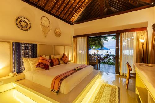 a bedroom with a bed with a view of the ocean at Living Asia Resort and Spa in Senggigi