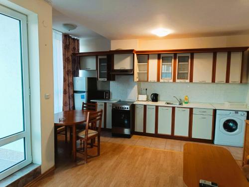 a kitchen with a table and a dining room at Riviera Fort Beach Apartment in Ravda