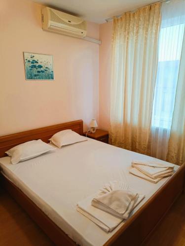 a bedroom with a bed with two towels on it at Riviera Fort Beach Apartment in Ravda