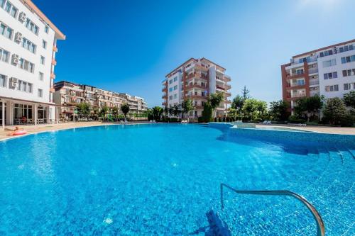 a large swimming pool in the middle of some buildings at Riviera Fort Beach Apartment in Ravda