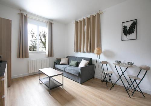 un salon avec un canapé et une table dans l'établissement Cozy et bien équipé près de Paris, à Saint-Maur-des-Fossés