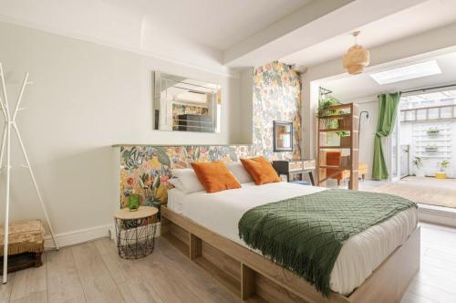 a bedroom with a large bed with orange pillows at Madeira Guest House in Brighton & Hove