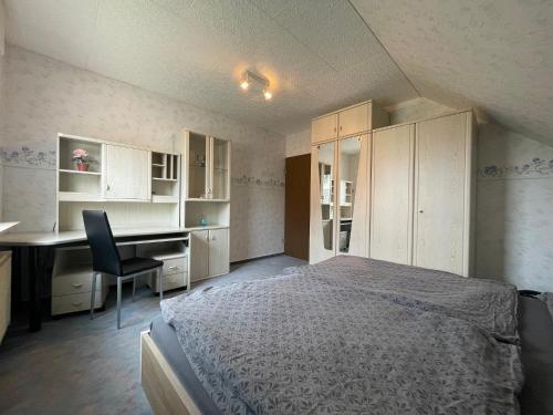 a bedroom with a bed and a desk and cabinets at Ferienwohnung Ludwig in Karlstadt