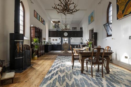 a dining room with a wooden table and chairs at The Old Church in Ringwood