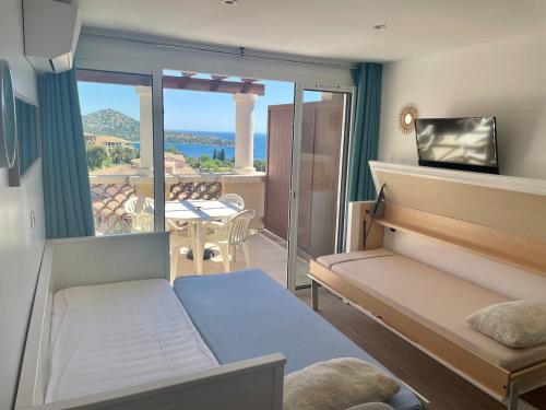 Cette chambre comprend un lit et un balcon avec vue. dans l'établissement Cap Esterel MAGNIFIQUE VUE MER 5 pers CLIMATISÉ, à Saint-Raphaël