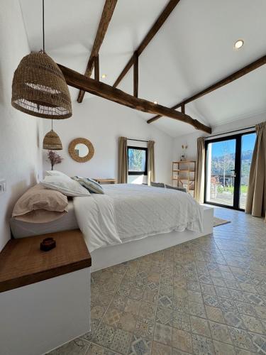 a bedroom with a large bed and a large window at As Casas Do BomPai - Las Oliveiras in São Julião