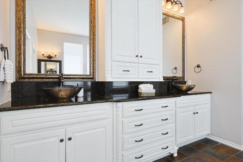 a bathroom with two sinks and a mirror at Lakefront Living, Elegant 5BD Home on Lake Ray Hubbard in Rowlett