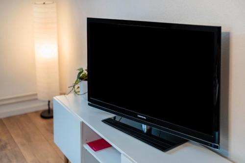 a flat screen tv sitting on a white entertainment center at Ferienwohnung im Grünen in Oppenau