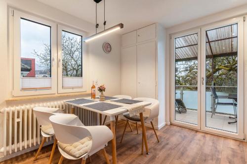 a dining room with a table and chairs and windows at Ferienwohnung im Grünen in Oppenau