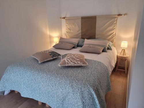 une chambre avec un grand lit avec deux oreillers dessus dans l'établissement Maison de charme en bord de mer, à Batz-sur-Mer
