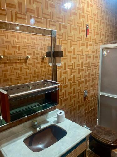 ジュアゼイロ・ド・ノルテにあるSuíte Central Confortの洗面台、鏡、トイレ付きのバスルーム