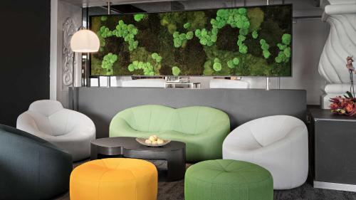 a living room with green and white chairs and a table at Hotel Central in Hof