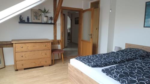a bedroom with a bed and a wooden dresser at Apartmán v podkroví Olomouc in Olomouc