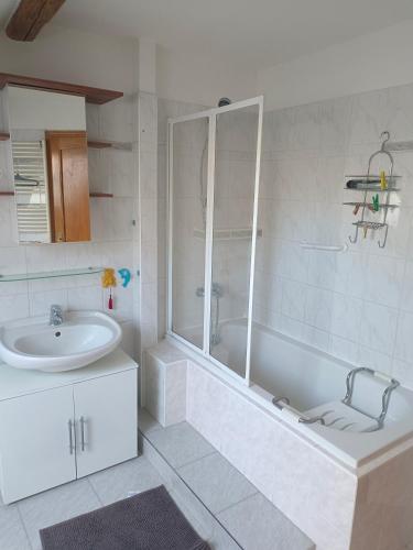 a white bathroom with a tub and a sink at Apartmán v podkroví Olomouc in Olomouc