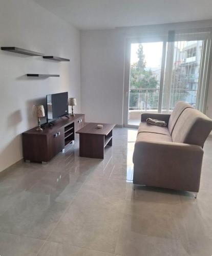 a living room with a couch and a tv at Happy stay 1 in Marsaxlokk