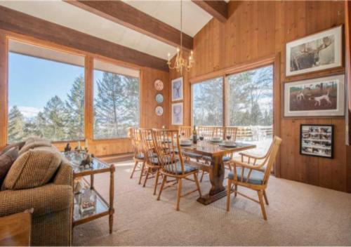 a living room with a dining room table and chairs at Bray House - Ski-in Ski-out family home in Teton Village