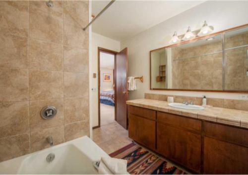 a bathroom with a tub and a sink and a mirror at Bray House - Ski-in Ski-out family home in Teton Village