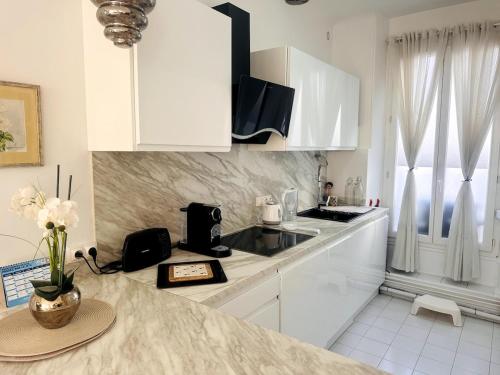 une cuisine avec des armoires blanches et un comptoir dans l'établissement One Bedroom apartment in Cannes Center a few steps from the Croisette and the Martinez Hotel - 2032, à Cannes