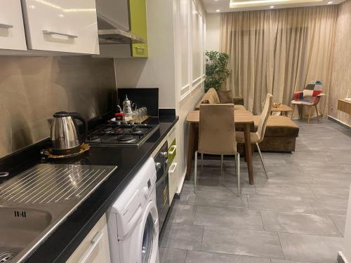 a kitchen with a stove top oven next to a table at Downtown delight studio in Casablanca
