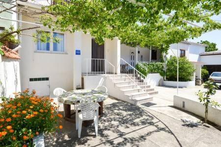 a table and chairs in front of a house at Schönes Haus Mit Privatem Garten in Zadar
