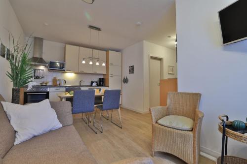 un salon avec un canapé et des chaises et une cuisine dans l'établissement Residenz Haffblick Wohnung 31, à Boltenhagen