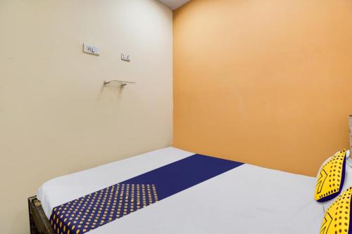 a bedroom with a bed with a blue and white bedspread at SPOT ON Hotel Sai Ashirwad Residency in Hyderabad