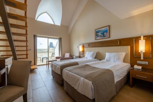 a hotel room with two beds and a window at Crystal Prestige Elite in Kemer