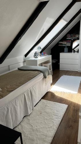 a attic bedroom with a bed and a white table at Villa in historical Uppåkra between Lund and Malmö in Staffanstorp