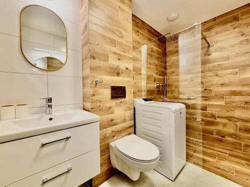 un bagno con un water, un lavandino e uno specchio di Apartament Viktoria w Perle Mórz blisko morza - Ustronie Morskie - Sianożęty a Sianozety