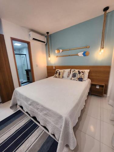 a bedroom with a large white bed with pillows at MANA BEACH MURO ALTO - by MB 016 in Porto De Galinhas