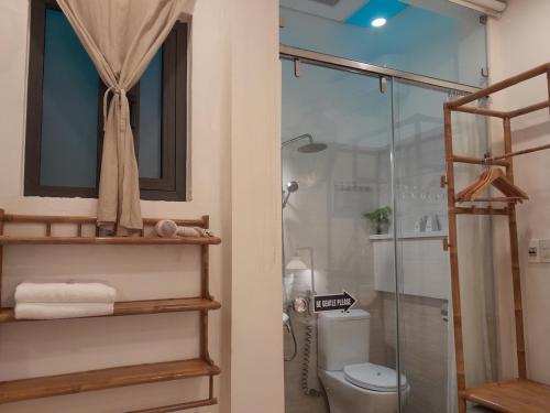 a bathroom with a glass shower with a toilet at Tâm Homestay in Hue