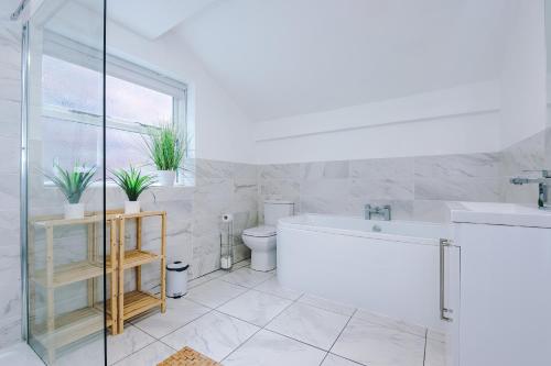 a bathroom with a tub and a sink and a toilet at Stylish 3-Bed City Centre Home in Chester by 53 Degrees Property, Ideal for Groups, Private Parking! in Chester
