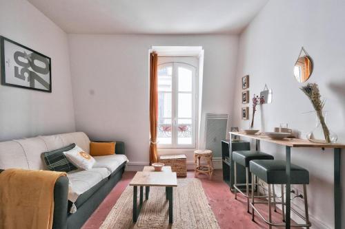 un salon avec un canapé et une table dans l'établissement Lovely Studio Place de la Bastille, à Paris