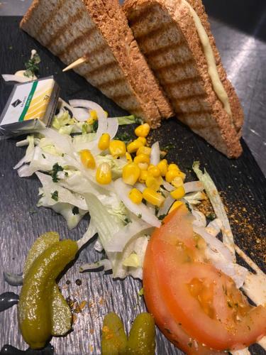 a plate of food with corn and vegetables and a sandwich at Kyriad SEDAN in Sedan