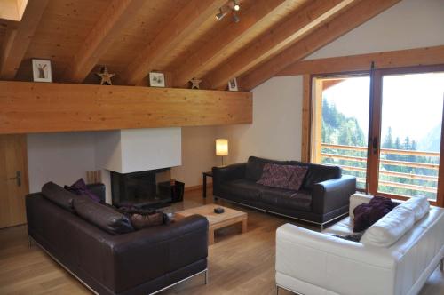 a living room with two couches and a fireplace at Appartement ski in and ski out in Val-d'Illiez