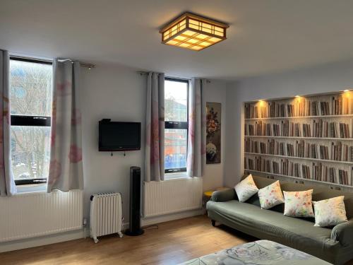 a living room with a couch and a tv at Lovely apartment near Gatwick airport in Reigate