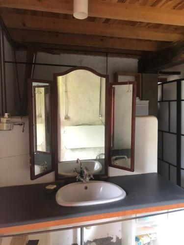 une salle de bain avec un lavabo et un miroir dans l'établissement Maison accueillante avec jardin à Sainte-Suzanne, à Sainte-Suzanne