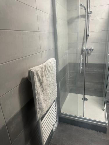 d'une douche avec une porte en verre et une serviette. dans l'établissement Studio du Château, à Jonzac