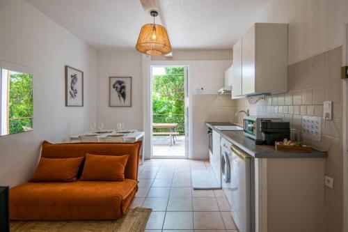 une cuisine avec un canapé orange dans une chambre dans l'établissement le Canopée 3 pers appart F1 terrasse fibre centre-ville, à Millau