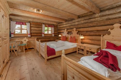 ラムサウ・アム・ダッハシュタインにあるBrandhof - Chalet am Bergのログキャビンベッドルーム(ベッド2台、デスク付)