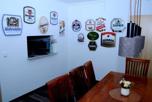 a dining room with a table and signs on the wall at Bonsai-Ferienwohnung in Bad Laer