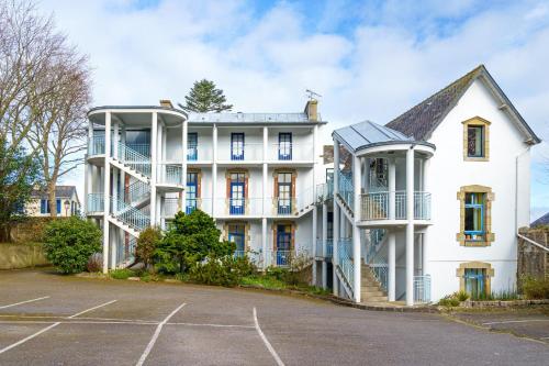 a large white house with a parking lot at Ty Louise - Studio vue mer in Douarnenez