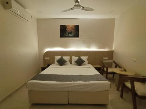 a bedroom with a bed and a ceiling fan at Hotel Meridian Blue in Warangal