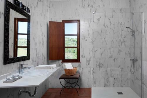 Un baño blanco con lavabo y espejo. en Monte do Forno, en Vila Nova de Cacela