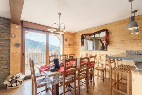 une salle à manger avec une table et des chaises et un balcon dans l'établissement Les Genévriers - Vue montagne, à Ventron