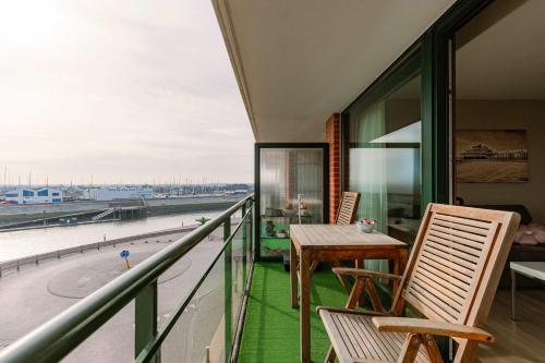 un balcon avec une table et des chaises et une vue dans l'établissement Cozy studio with harbor view in Blankenberge, à Blankenberge