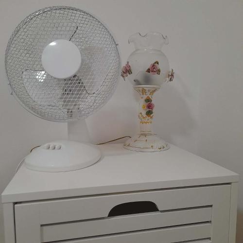 a white dresser with a fan and a lamp at Villa Sabic in Sarajevo