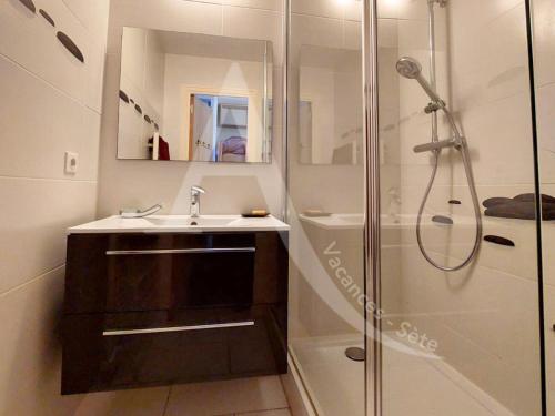 une salle de bain avec un lavabo et une douche dans l'établissement CAP CORNICHE piscine, studio cabine 4 personnes clim, wifi et parking, à Sète